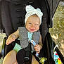baby, child, stroller, headband, pacifier, smile, blue_eyes, sunlight, outdoor, infant, clothing, seatbelt, playful, happy, person, cute, toy, nature, seat, portrait