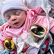 Lilliona is registered to the contest to win money with this photo: baby, newborn, sleeping, pink_clothing, hat, crocheted_blanket, golden_eggs, easter, hand, fabric, closeup, indoor, soft_light, cute, infant, resting, portrait, child, person, blanket