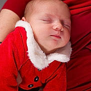 Liziana a rejoint le concours — aidez-le/la à gagner de superbes lots ! baby, sleeping, infant, red_clothing, santa_outfit, white_fur_trim, closeup, portrait, person, child, holiday, christmas, cozy, warm, hands, resting, cute, soft_texture, indoor, festive