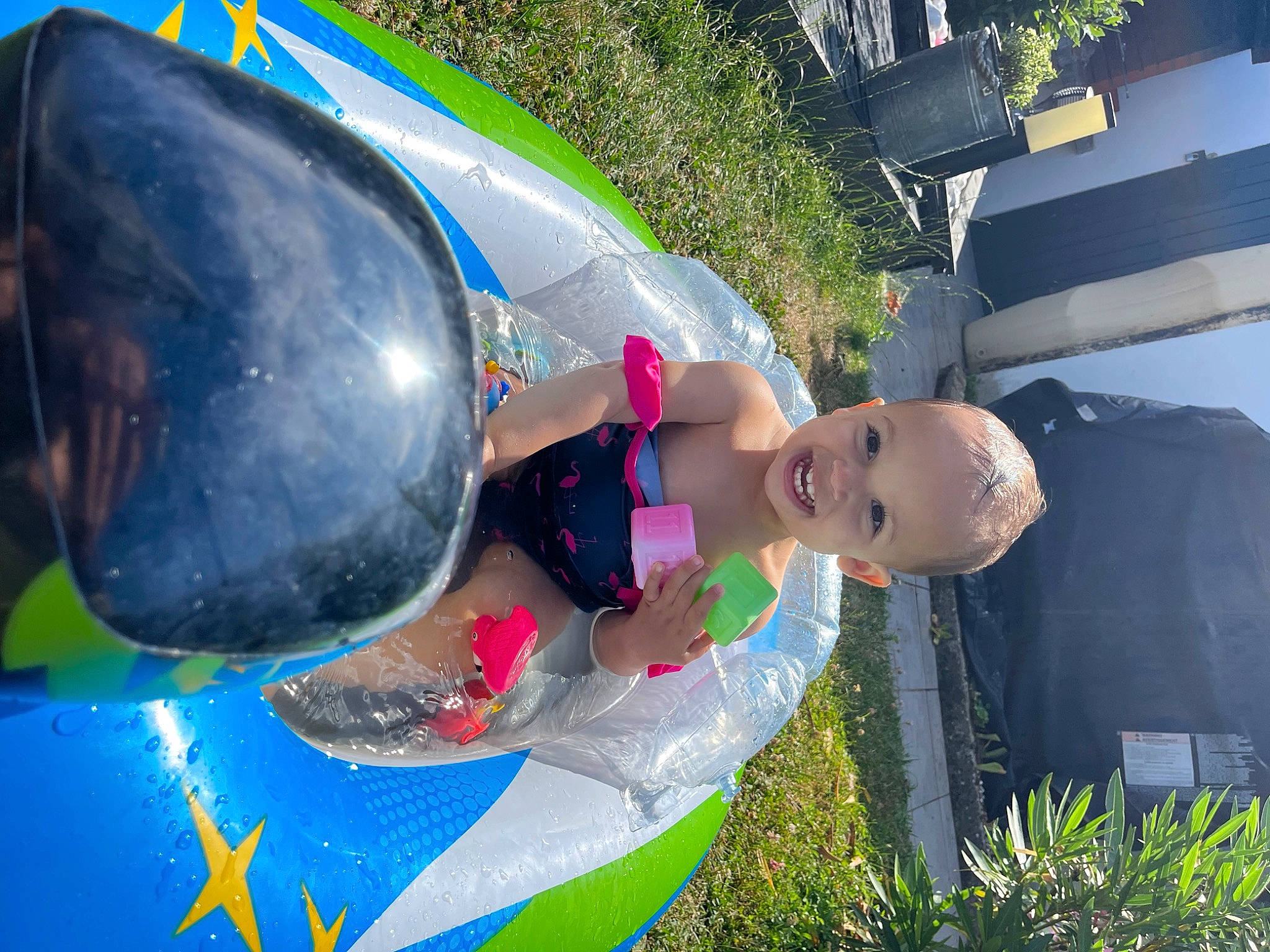 Inès participe au concours pour gagner de l'argent avec cette photo : child, chute, cool, fun, grass, happy, inflatable, leisure, people_in_nature, person, personal_protective_equipment, plant, play, recreation, smile, swimming_pool, swimwear, toddler, tree, vacation