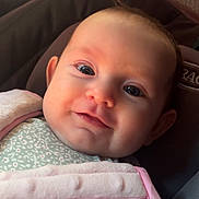 Serenity is registered to the contest to win money with this photo: baby, infant, face, smile, eyes, blanket, clothing, car_seat, child, cute, portrait, indoors, soft_light, closeup, warm_colors, skin, head, baby_girl, expression, happy