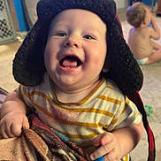 Theo joined the competition — help win amazing prizes! baby, blanket, blue_wall, candid, child, cute, diaper, expression, floor, furniture, happy, hat, headwear, home, indoor, person, playful, smiling, television, toddler