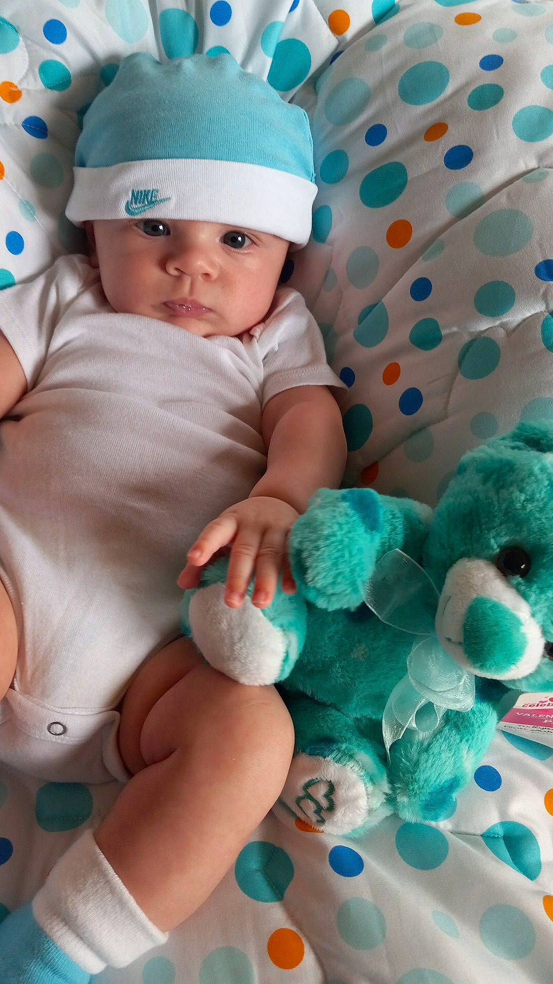 Kyler is registered to the contest to win money with this photo: aqua, azure, baby, baby_sleeping, baby_toddler_clothing, blue, cap, cheek, child, comfort, face, green, happy, headwear, linens, pattern, person, pink, skin, textile