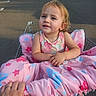 toddler, child, shopping_cart, blanket, pink, stars, parking_lot, hand, sandals, outdoor, sunlight, curly_hair, clothing, person, cute, expression, comfort, sitting, daytime, retail
