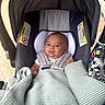 baby, car_seat, blanket, infant, child, seatbelt, canopy, toy, patterned_toy, knitted_blanket, person, cute, face, head, indoor, child_seat, infant_seat, comfort, rest, young_child