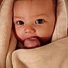 baby, blanket, face, hand, infant, wrapped, cozy, soft_texture, giraffe_pattern, curious_eyes, indoor, portrait, cute, skin, warm, newborn, baby_gesture, comfort, child, closeup