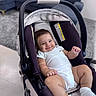 baby, infant, child, smiling, portrait, car_seat, indoors, living_room, sofa, rug, home, onesie, socks, seated, reclining, happy, face, short_hair, furniture, photography