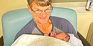 Kayden Jackowicz joined the competition — help win amazing prizes! man, baby, newborn, glasses, blanket, chair, hospital, hat, smile, person, indoor, holding, seated, window, bottle, male, adult, child, comfort, family