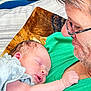 adult, arm, baby, blanket, closeup, comfort, couch, face, family, glasses, green_shirt, indoor, love, newborn, person, pillow, portrait, resting, skin, sleeping