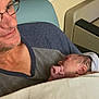 Kayden Jackowicz is registered to the contest to win money with this photo: man, newborn, baby, hospital, blanket, portrait, indoor, smile, glasses, person, resting, tender, headwear, hospital_room, adult, closeup, seated, comfort, family, holding