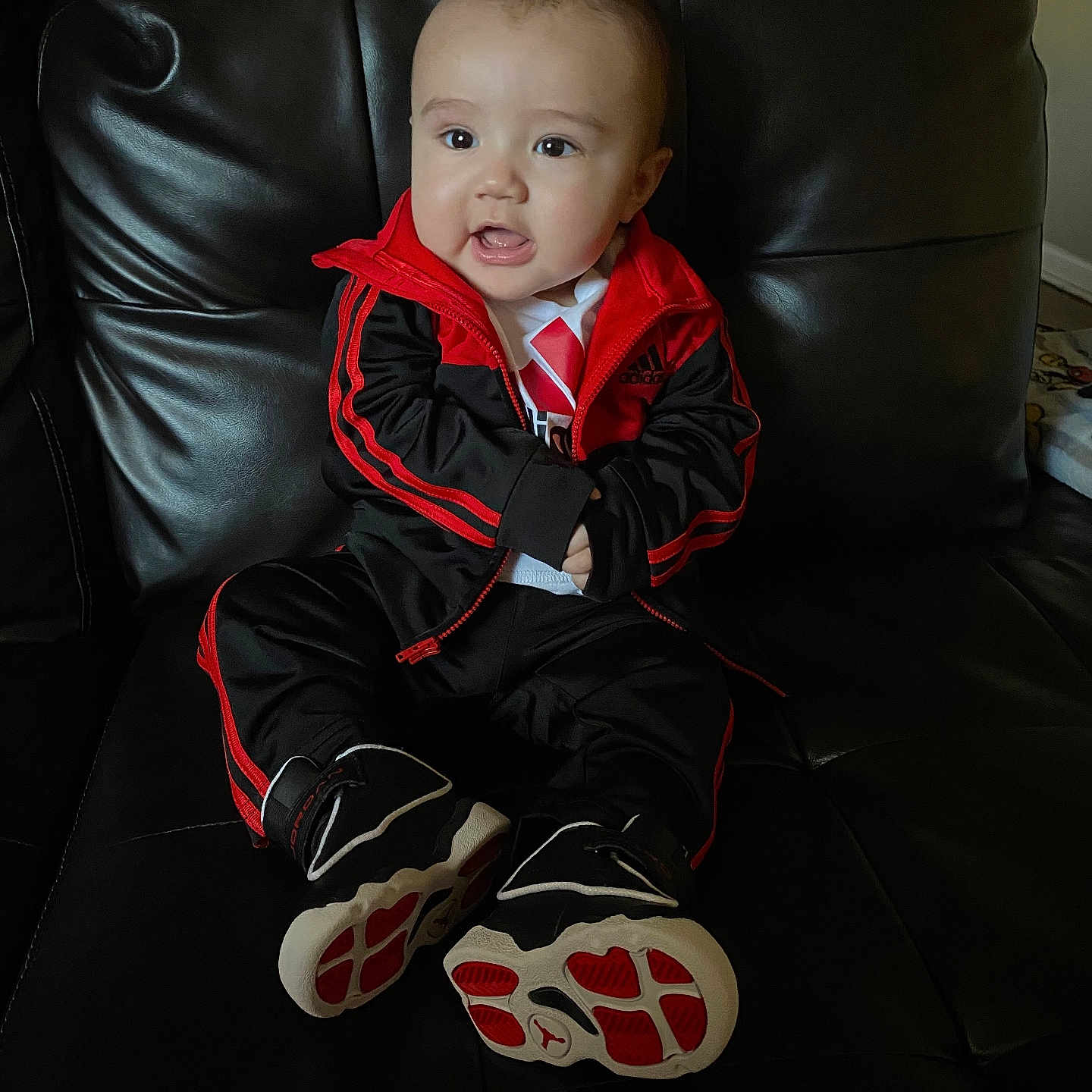 Oziah is registered to the contest to win money with this photo: baby, ball, chair, clothing, coat, couch, cushion, face, footwear, furniture, head, homedecor, jacket, pants, person, photography, portrait, shoe, sitting, sneaker