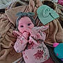 baby, infant, headband, bow, blanket, bedding, onesie, floral_pattern, hand, eyes, face, hat, plush_toy, toy, bed, cozy, pink_clothing, skirt, newborn, lying_down