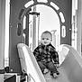 barefoot, black_and_white, child, clothing, curious, daylight, fun, happy, jeans, leisure, outdoor, park, person, play, playground, shirt, slide, toddler, toy, young_child
