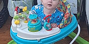 Christopher joined the competition — help win amazing prizes! baby, child, walker, pajamas, toys, floor, wooden_floor, cabinet, trash_can, indoor, curious, colorful, playtime, foot, face, person, home, furniture, expression, early_childhood
