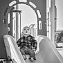Christopher joined the competition — help win amazing prizes! black_and_white, casual_clothing, child, curious, daylight, expression, footwear, jeans, looking_up, monochrome, outdoor, plaid_shirt, plastic_slide, play_equipment, playground, recreation, sitting, slide, toddler, young_child