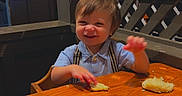 Kohen is registered to the contest to win money with this photo: advertisement, bread, child, clothing, coca_cola, decor, face, food, furniture, hair, happy, indoor, restaurant, seat, smile, suspenders, table, toddler, vintage, wood