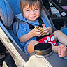 toddler, child, car_seat, smiling, food, waffle_fry, blue_shirt, seatbelt, car_interior, happy, cute, portrait, sunlight, baby, seat, foot, vehicle, window, safety, casual