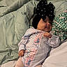 baby, infant, smiling, bed, blanket, clothing, headwear, black_bow, onesie, tights, cute, happy, lying_down, indoors, child, person, soft_fabric, cozy, pattern, portrait