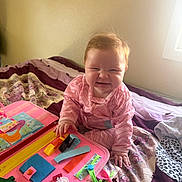 Lillian joined the competition — help win amazing prizes! baby, child, pajamas, bed, quilt, toy, busy_board, pink, purple, floral_pattern, hand, face, smile, indoor, window, light, playing, furniture, person, cute