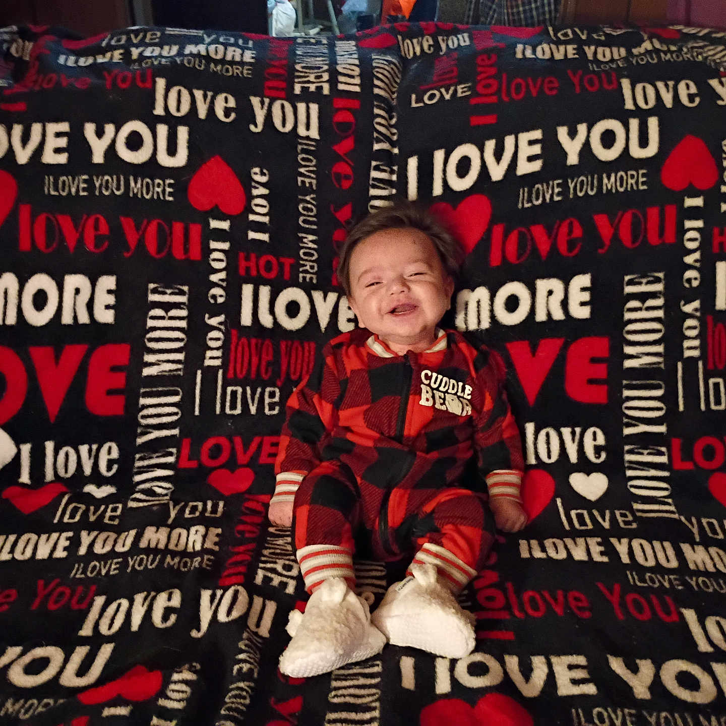 Chance joined the competition — help win amazing prizes! baby, blanket, child, couch, cozy, cuddle_bear, cute, footwear, happy, heart, indoor, infant, love_you, onesie, portrait, red_black_checkered, sitting, smiling, text_pattern, warm