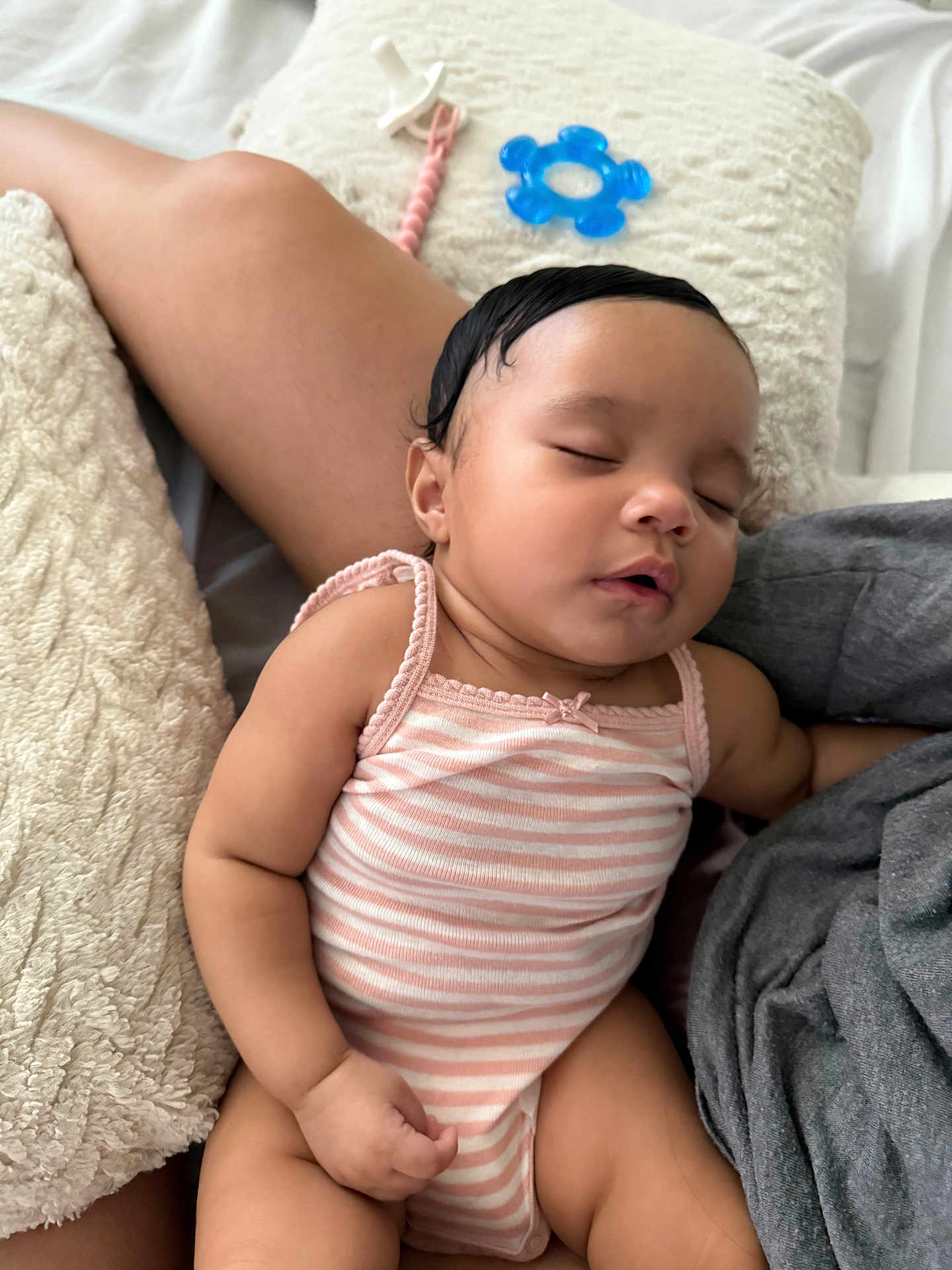 Skylar is registered to the contest to win money with this photo: baby, sleeping, infant, onesie, pink_stripes, pillow, soft_texture, cuddling, peaceful, cute, child, person, skin, arm, hand, closed_eyes, rest, comfort, indoors, relaxation