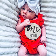 Adley joined the competition — help win amazing prizes! baby, infant, one_month, red_clothing, white_bow, headband, blanket, soft_texture, cute, newborn, portrait, lying_down, skin, hand, face, expression, milestone, wooden_sign, baby_girl, closeup