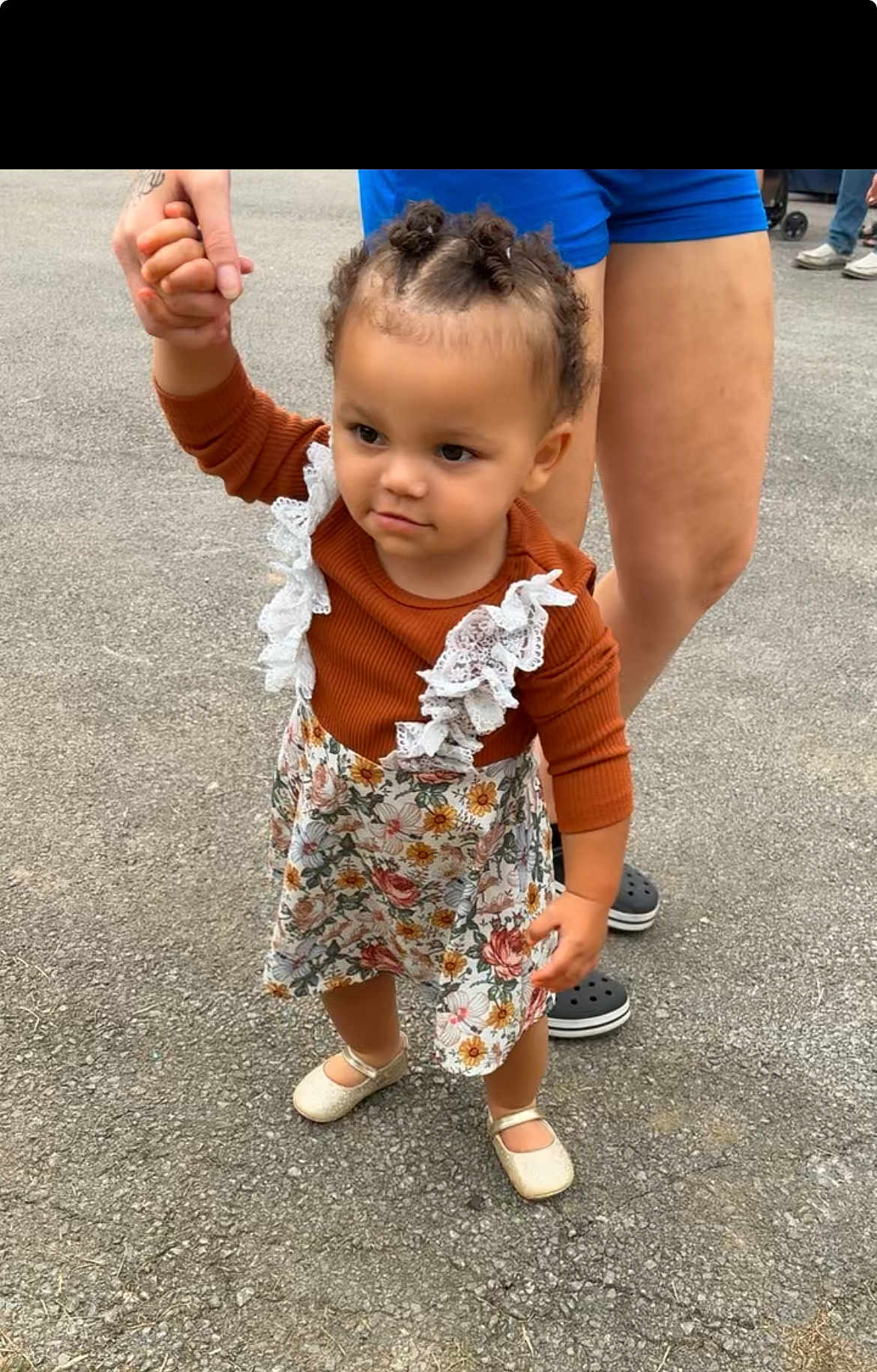 Tyleah joined the competition — help win amazing prizes! toddler, child, holding_hand, curly_hair, floral_dress, lace, long_sleeve, rust_color, cream_shoes, adult, blue_shorts, black_crocs, outdoor, gravel, walking, person, cute, young_child, protective, summer