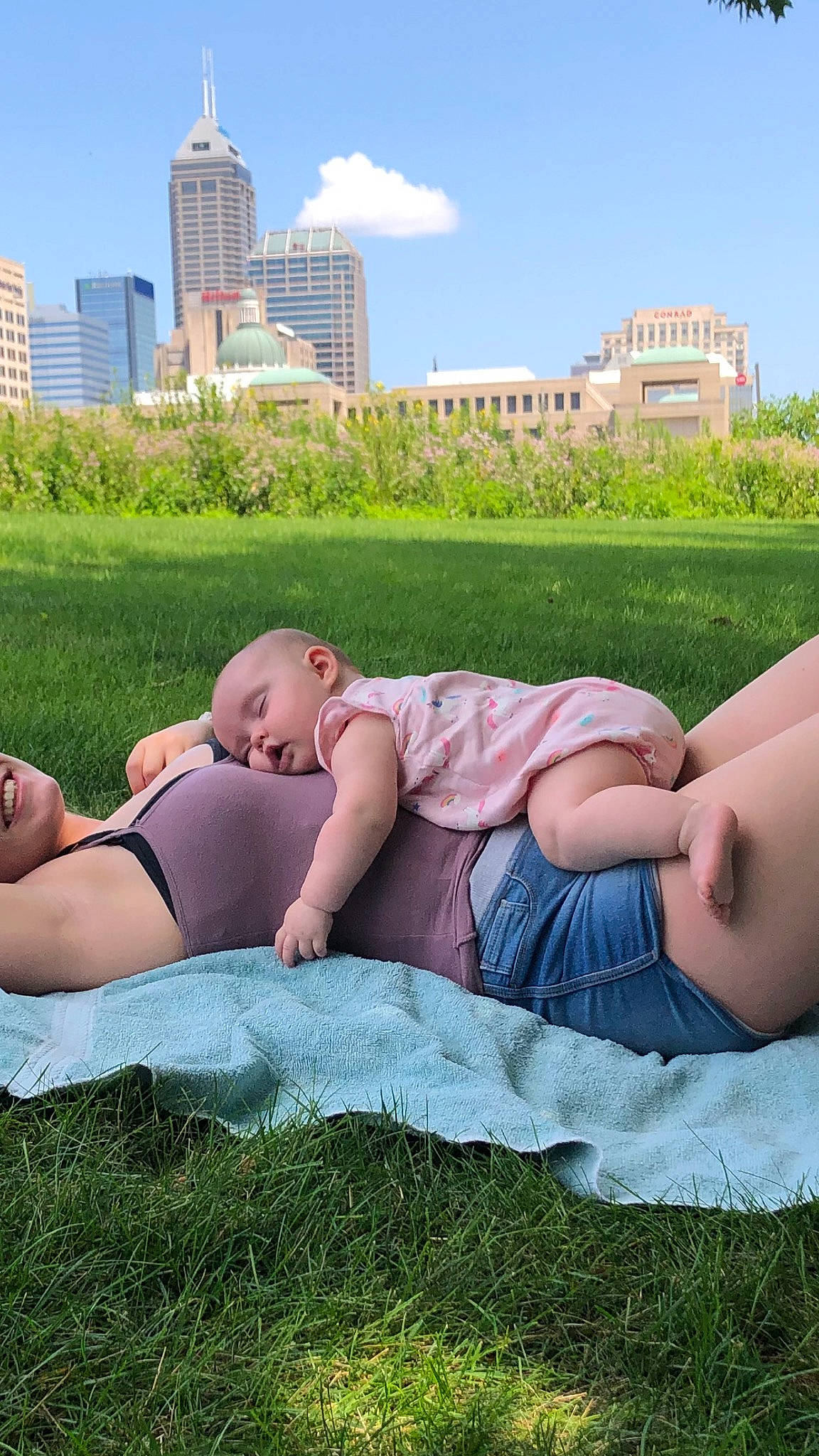 Otis Mae is registered to the contest to win money with this photo: building, comfort, daytime, grass, grassland, green, happy, leaf, leisure, meadow, morning, people_in_nature, person, plant, shorts, shoulder, sky, thigh, tower, tower_block