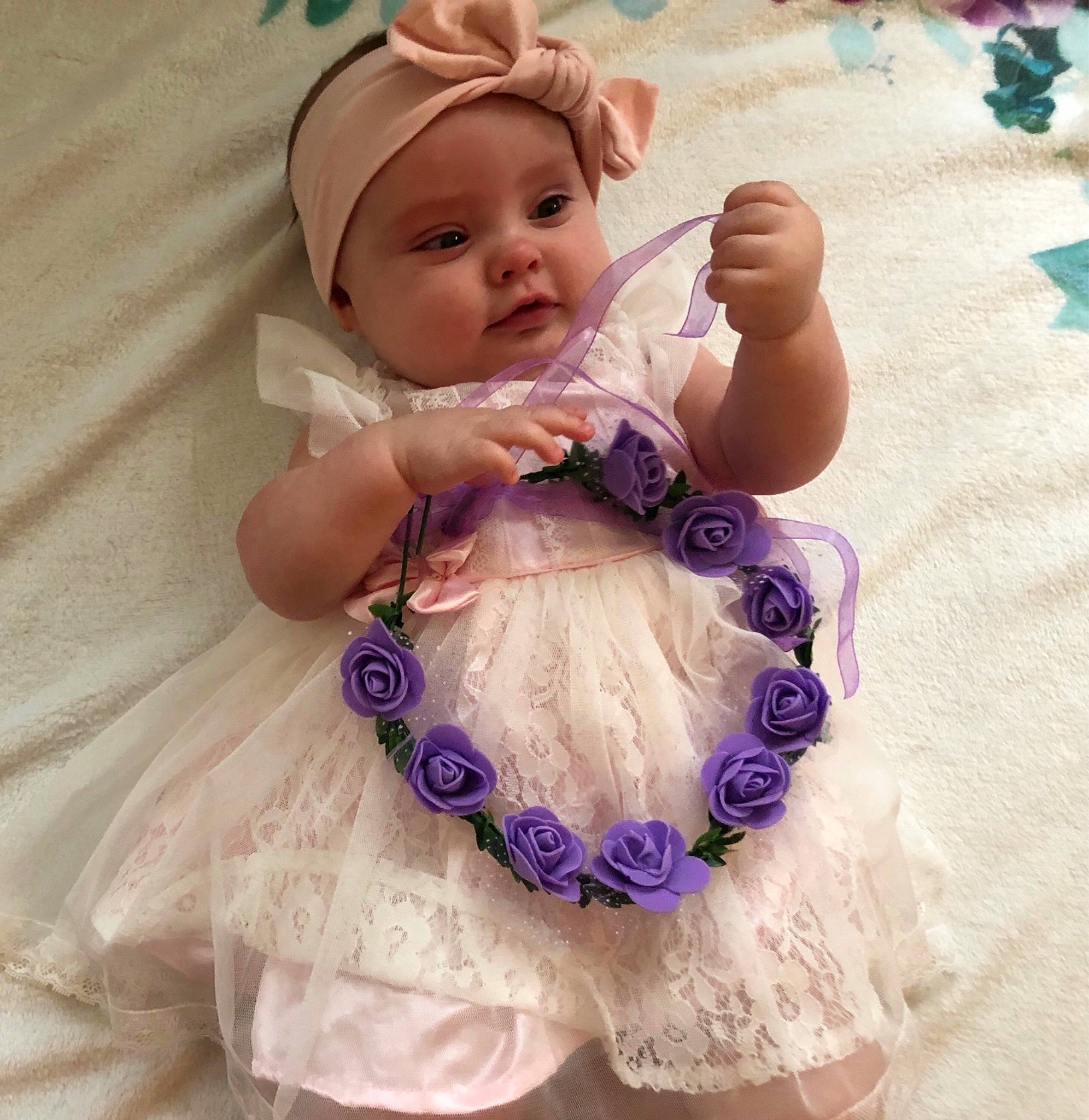 Otis Mae is registered to the contest to win money with this photo: baby, baby_toddler_clothing, doll, dress, face, happy, head, headband, headgear, headpiece, headwear, mythical_creature, person, petal, photograph, pink, product, purple, skin, smile