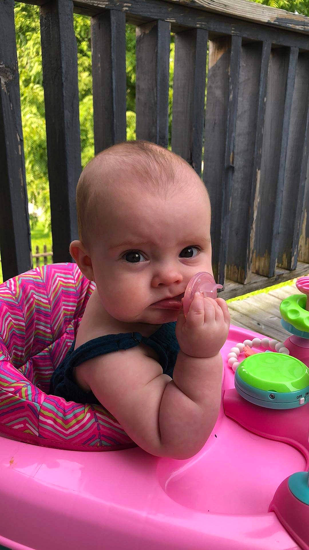 Otis Mae is registered to the contest to win money with this photo: arm, baby, baby_playing_with_toys, baby_products, baby_toddler_clothing, cheek, child, finger, fun, grass, happy, leisure, lip, person, pink, recreation, sitting, skin, table, toddler