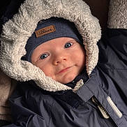 Stefan is registered to the contest to win money with this photo: baby, child, face, hood, jacket, winter_clothing, beanie, smile, blue_eyes, warm, soft_texture, coat, zipper, closeup, portrait, cute, infant, apparel, indoors, person