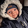 baby, child, face, hood, jacket, winter_clothing, beanie, smile, blue_eyes, warm, soft_texture, coat, zipper, closeup, portrait, cute, infant, apparel, indoors, person