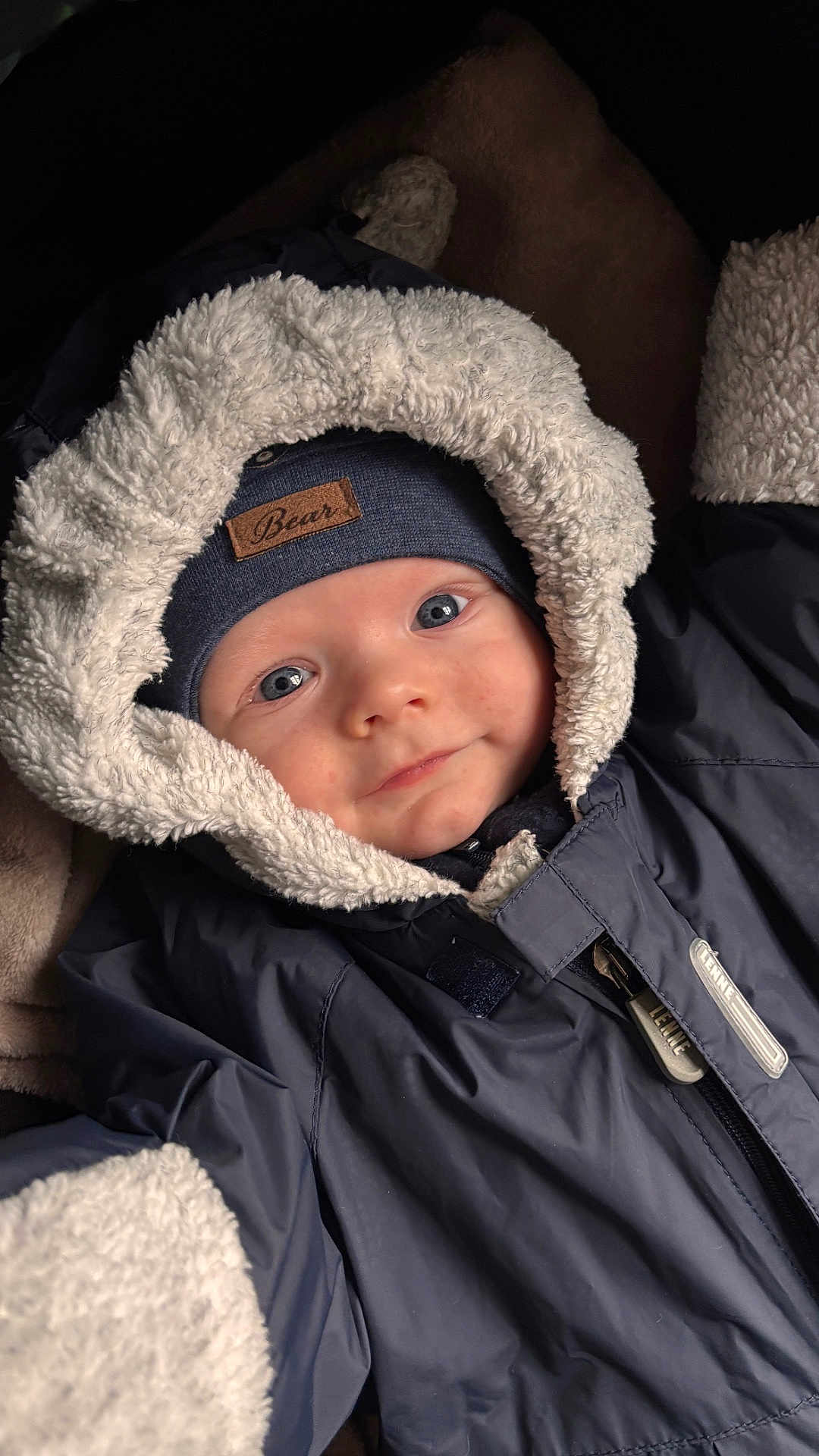 Stefan is registered to the contest to win money with this photo: baby, child, face, hood, jacket, winter_clothing, beanie, smile, blue_eyes, warm, soft_texture, coat, zipper, closeup, portrait, cute, infant, apparel, indoors, person