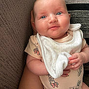 Siennarose joined the competition — help win amazing prizes! baby, infant, blue_eyes, onesie, bib, hand, couch, cushion, pattern, fabric, close_up, smile, skin, person, cute, child, indoor, soft_toy, holding, pink_dots