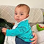Alfie is registered to the contest to win money with this photo: baby, bodypart, clothing, coat, couch, cushion, face, finger, furniture, hand, head, homedecor, jacket, jeans, pants, people, person, photography, portrait, sitting