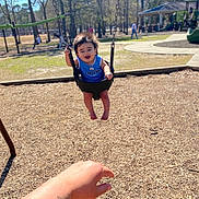 Josiah joined the competition — help win amazing prizes! child, toddler, swing, playground, park, baby_swing, smile, happy, parent_hand, wood_chips, trees, sunny, outdoor, play, grass, person, daylight, recreation, casual_clothing, fun