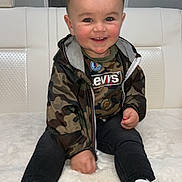 Vincy a rejoint le concours — aidez-le/la à gagner de superbes lots ! child, toddler, smiling, sitting, white_shoes, camo_jacket, levis_shirt, fluffy_blanket, indoor, happy, cute, person, fashion, casual, portrait, face, young_child, clothing, shoes, hair
