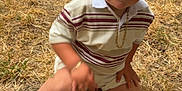 Vincy participe au concours pour gagner de l'argent avec cette photo : child, toddler, smiling, kneeling, grass, outdoor, striped_shirt, shorts, black_sneakers, gold_chain, happy, person, casual_clothing, summer, event, people, background, blurred, fun, daylight