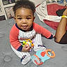 Bobby joined the competition — help win amazing prizes! baby, child, toy, pajamas, bed, quilt, blanket, indoor, person, smiling, face, hand, arm, wristband, colorful, play, cute, young, seated, comfort