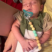 Walker is registered to the contest to win money with this photo: baby, sleeping, pacifier, child, infant, person, hand, arm, clothing, blanket, fabric, beads, comfort, cute, rest, indoor, toddler, skin, holding, peaceful