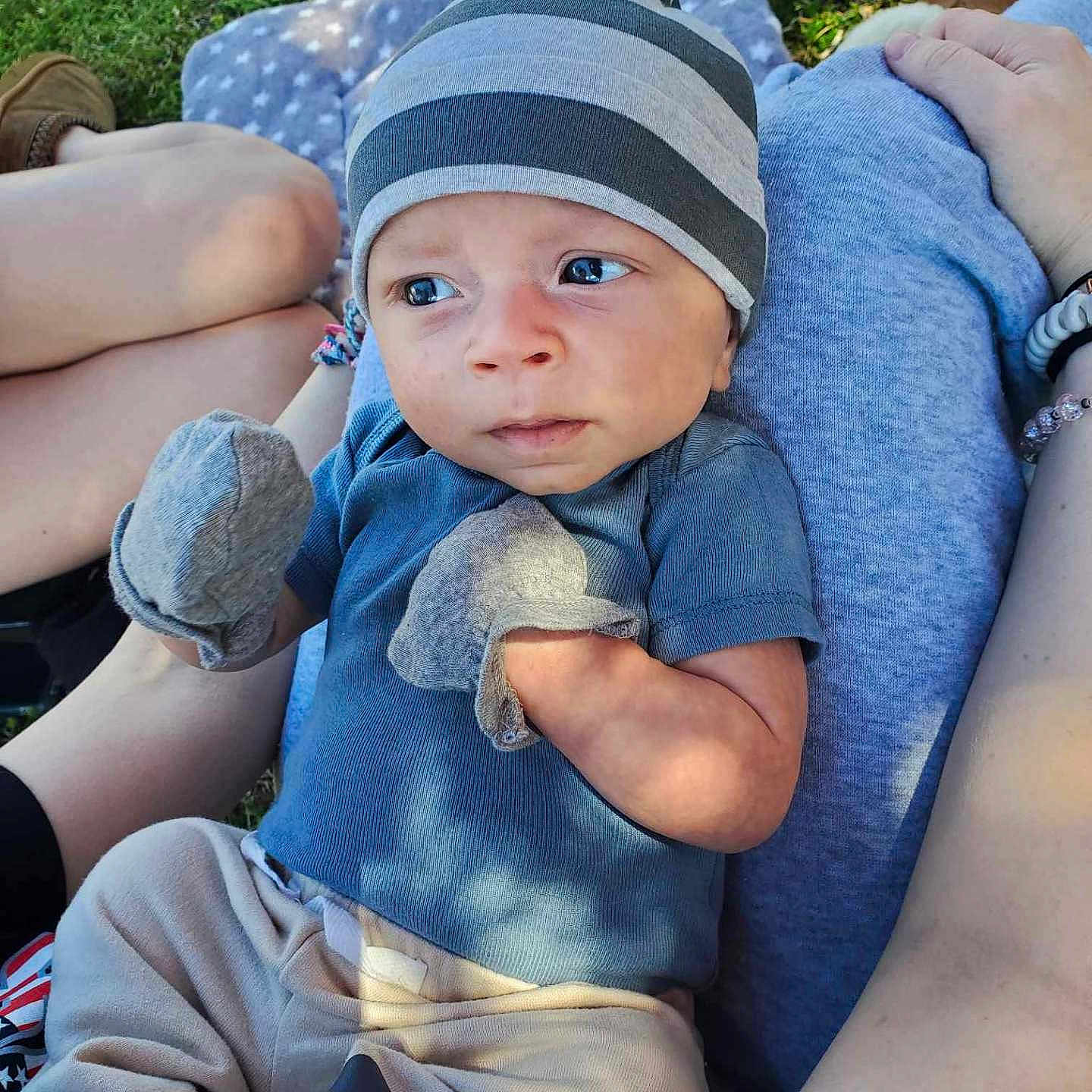 Milo is registered to the contest to win money with this photo: baby, baseballcap, blanket, cap, clothing, couch, face, footwear, furniture, grass, hat, head, jeans, pants, person, photography, plant, portrait, shorts, t_shirt