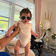 Iker joined the competition — help win amazing prizes! baby, child, sunglasses, hand, indoor, birthday_balloon, flowers, curtains, window, stroller, furniture, person, clothing, light, face, skin, room, decor, celebration, couch
