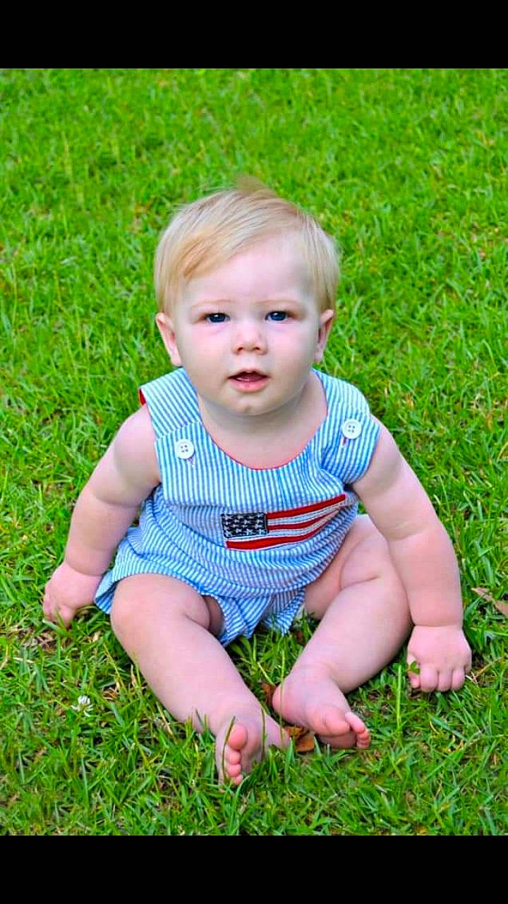 Spencer is registered to the contest to win money with this photo: baby, baby_toddler_clothing, child, grass, grass_family, lawn, meadow, people_in_nature, person, photography, plant, sitting, smile, toddler