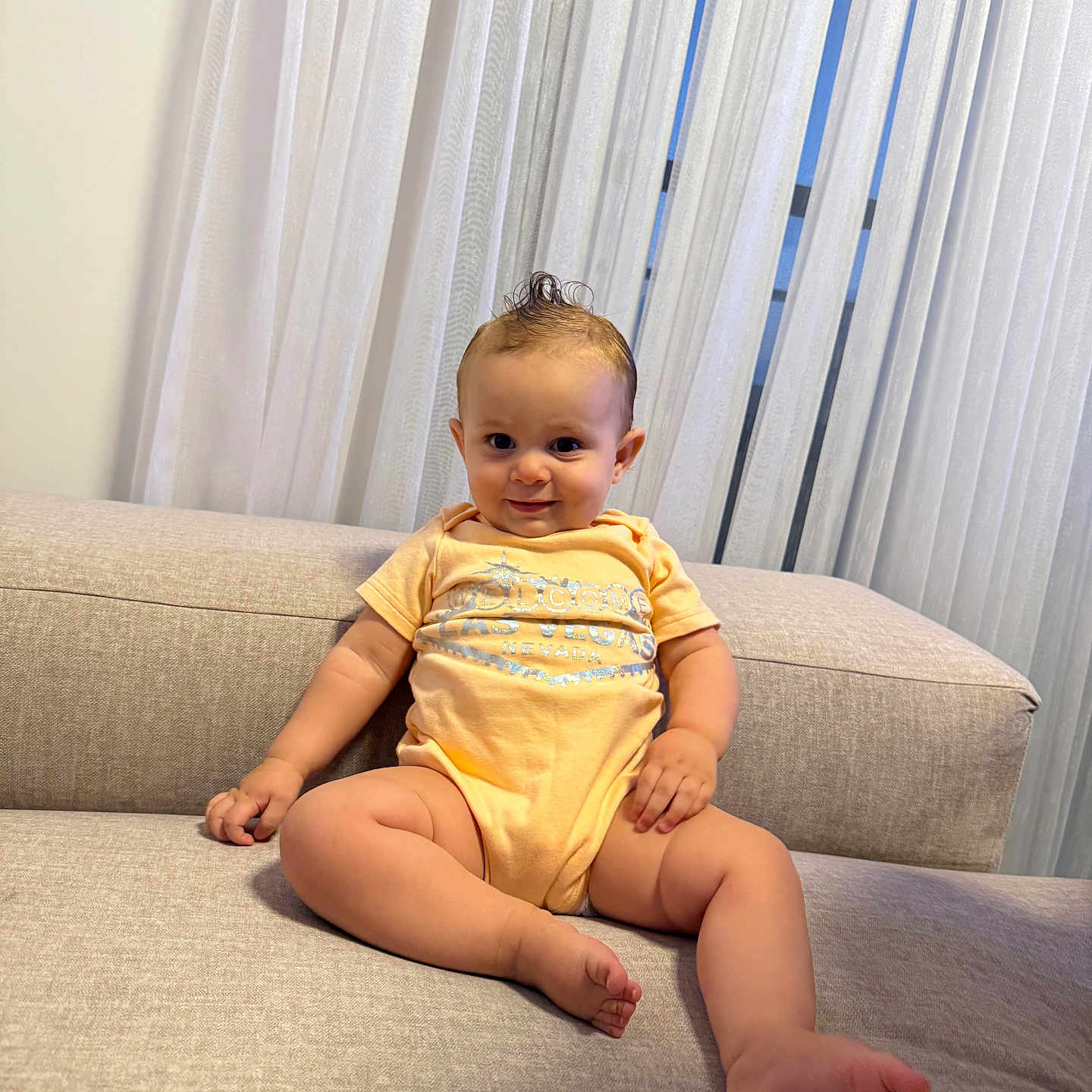 Billy a rejoint le concours — aidez-le/la à gagner de superbes lots ! baby, child, couch, curtains, fabric, face, feet, furniture, hairstyle, hand, happy, home, indoor, infant, legs, mohawk, onesie, person, smile, sofa