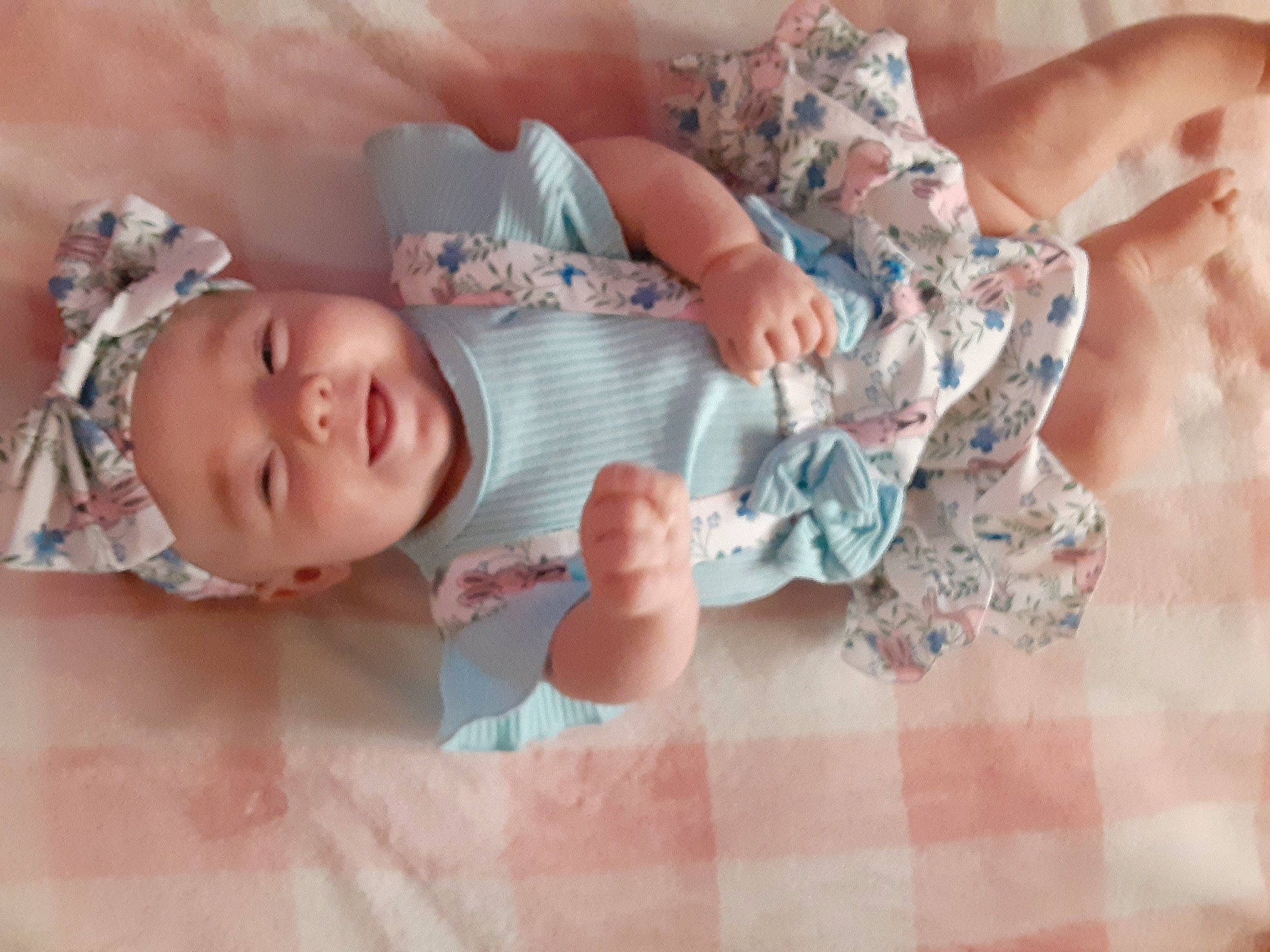 Lucinda is registered to the contest to win money with this photo: arm, baby, baby_products, baby_toddler_clothing, cheek, child, comfort, finger, gesture, hand, happy, headwear, human_body, linens, pattern, person, pink, room, skin, sleeve
