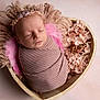 newborn, baby, sleeping, wrapped, pink, blanket, headband, flowers, wooden_bowl, heart_shape, soft_texture, portrait, peaceful, infant, cute, closeup, studio, adorable, child, resting