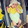 baby, infant, stroller, hat, yellow_clothing, white_clothing, outdoor, sunlight, cute, child, person, legs, feet, hand, expression, portrait, seat, fabric, zipper, comfort