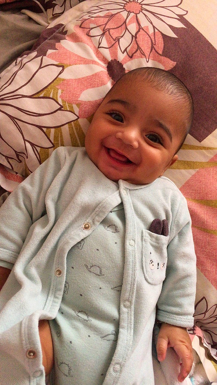 Farès participe au concours pour gagner de l'argent avec cette photo : baby, baby_toddler_clothing, cheek, child, chin, comfort, face, facial_expression, happy, headgear, human, joy, linens, lip, person, pink, product, skin, sleeve, smile