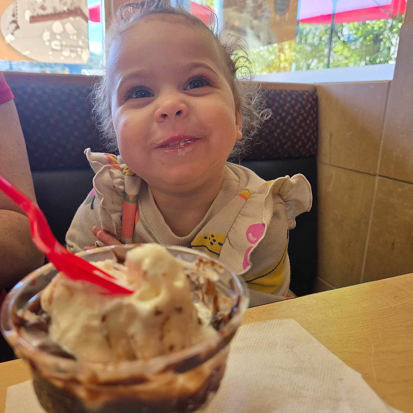 Nai'Ema joined the competition — help win amazing prizes! booth, child, clothing, cup, curly_hair, daylight, dessert, face, food, happy, ice_cream, indoor, person, restaurant, smiling, spoon, sweet, table, toddler, window