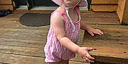 Nai'Ema joined the competition — help win amazing prizes! toddler, child, hat, romper, pink, white, shoes, socks, wooden_porch, bench, outdoor, standing, curious, baby, footwear, summer_clothing, door, planks, daylight, person